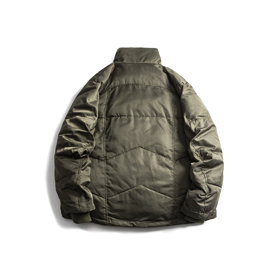 Back view of green quilted stand-collar jacket showing panel seams and ribbed cuffs, flat lay