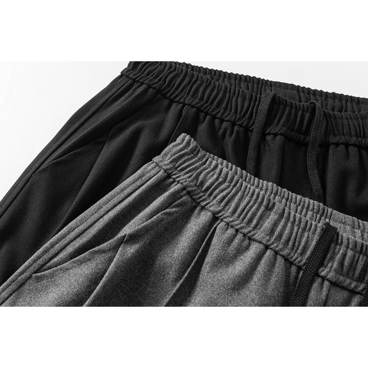 Close-up of black and charcoal wide-leg pants showing elastic waistbands and black drawstrings.