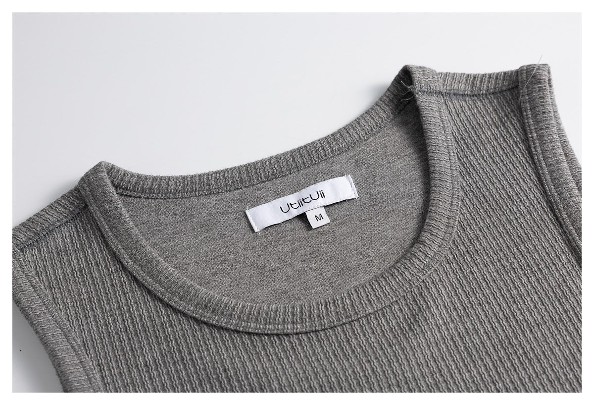 Close-up of a gray textured knit top's round neckline, with a sewn label and size M tag.