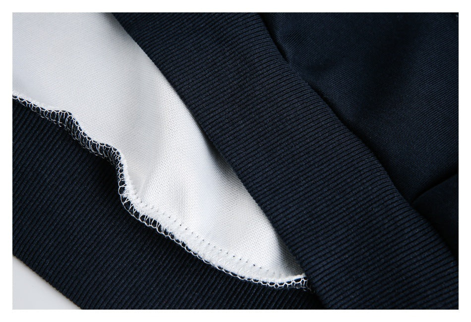 Close-up of a dark navy garment seam with white inner fabric and visible overlock stitching.