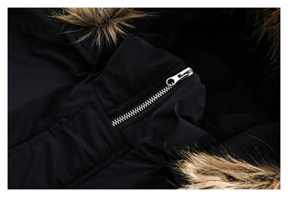 Close-up of a silver zipper and placket on a black coat, with fur trim at the edges.