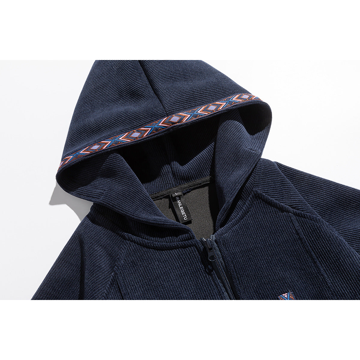 Close-up of a navy zip-up hoodie hood with multicolor geometric trim and a visible neck label.