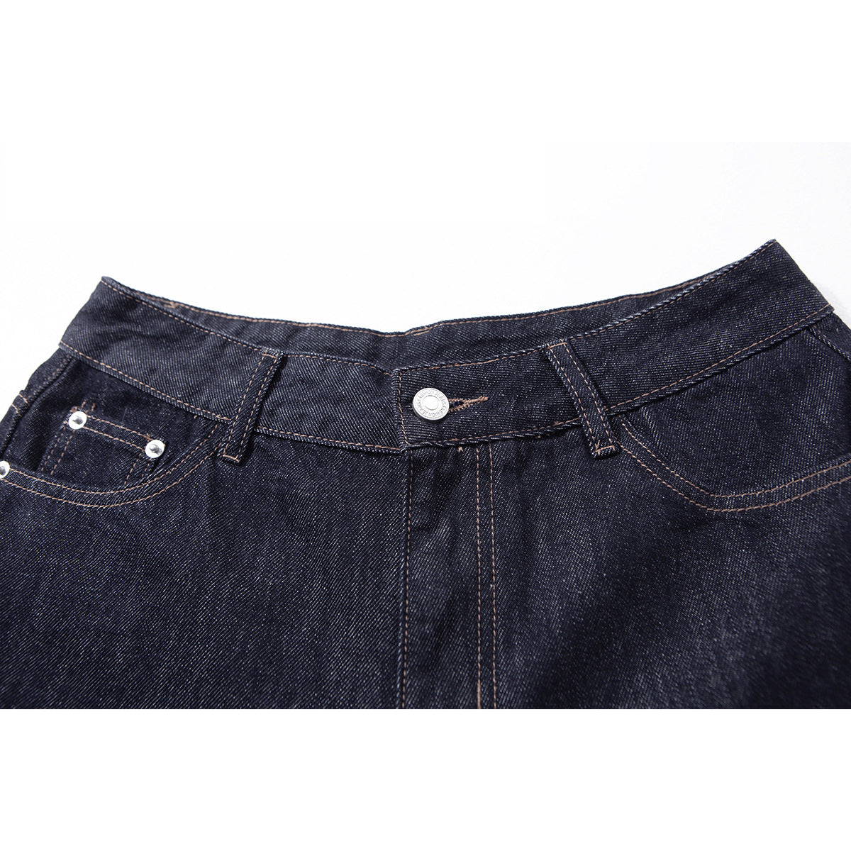 Close-up of dark indigo jeans showing the front waistband, metal button, belt loops, and riveted coin pocket.