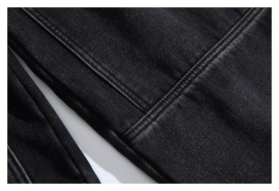 Macro view of black denim with prominent double-stitched seams.