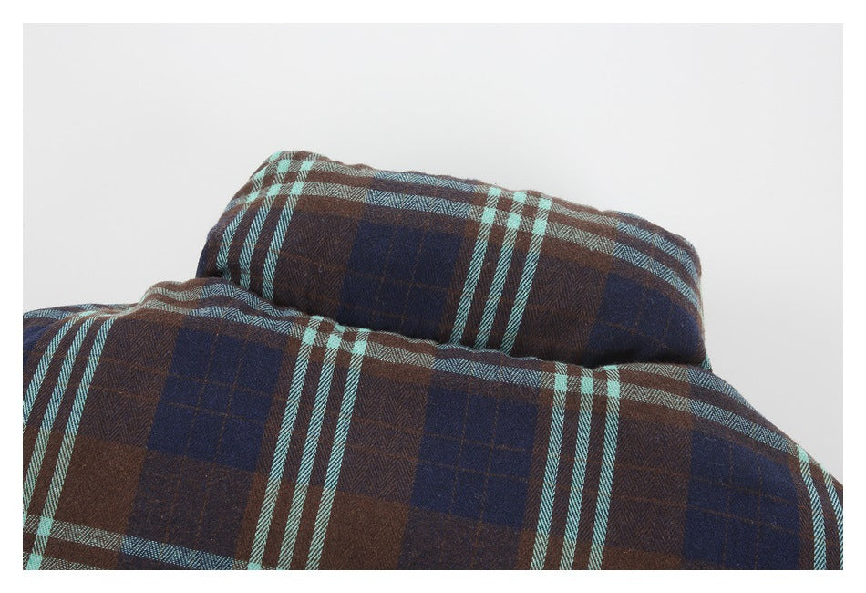 Close-up of a folded collar on a brown and navy plaid garment with pale aqua stripes.
