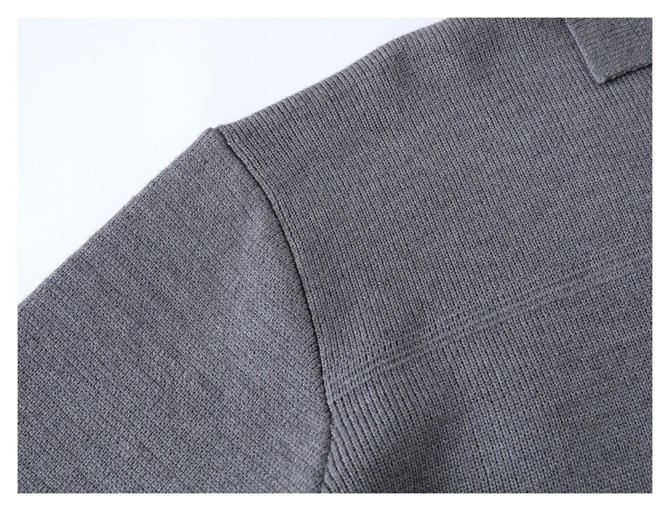 Close-up of the gray sweater's knit texture and shoulder seam.