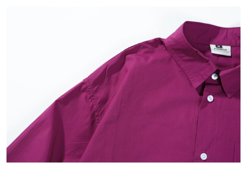Close-up of the magenta shirt's shoulder, collar, white buttons, and sleeve seam.