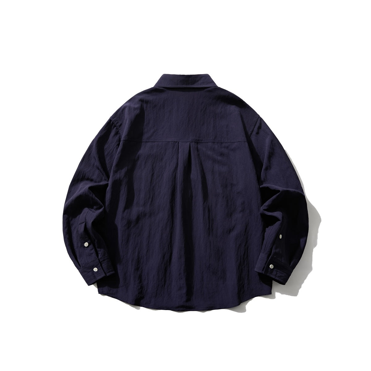 Back view of a navy long-sleeve button-up shirt with a center pleat and buttoned cuffs.