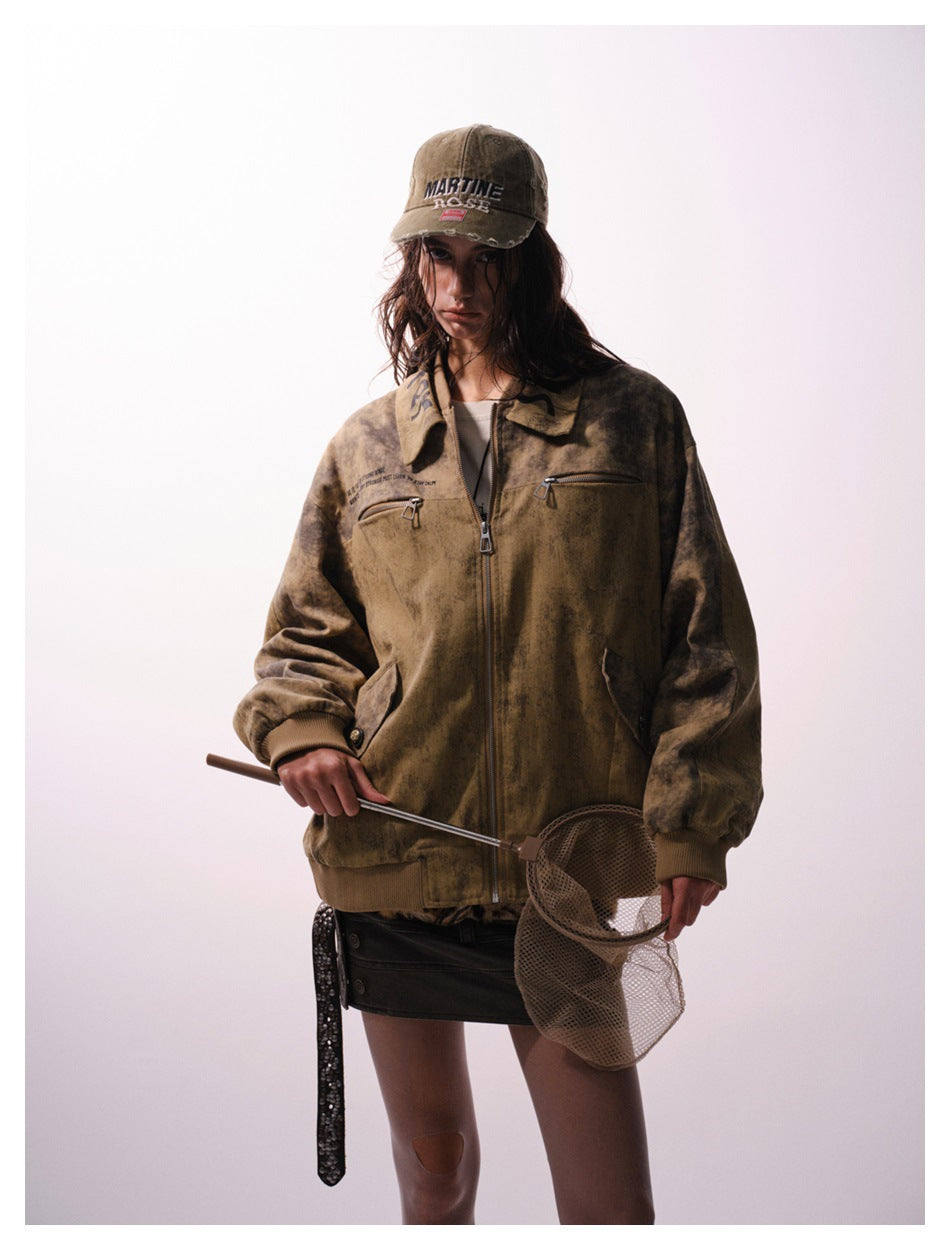 Full-length model wearing a mottled brown zip jacket with ribbed cuffs, a tan cap, and a short black skirt.