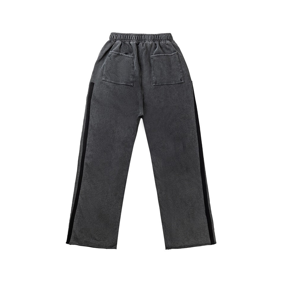 Back of washed dark gray sweatpants with elastic waistband, two patch pockets and black side stripes