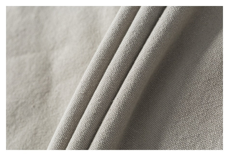 Close-up of textured light beige jacket fabric arranged in soft folds.