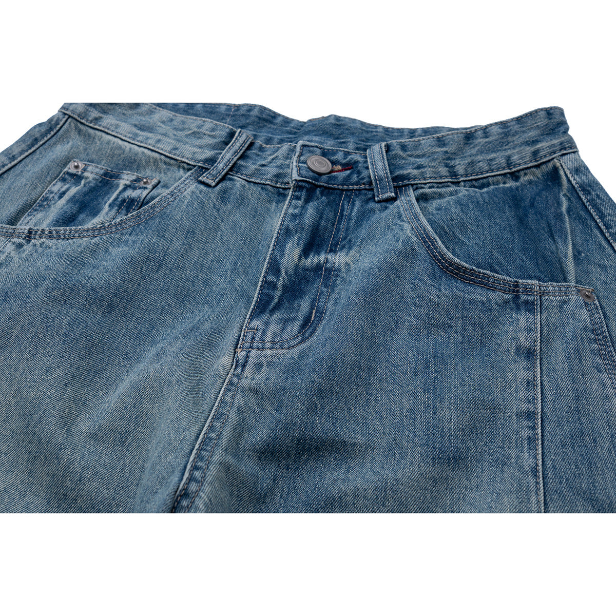 Close-up of the front waistband, button, belt loops and pockets of faded blue jeans.