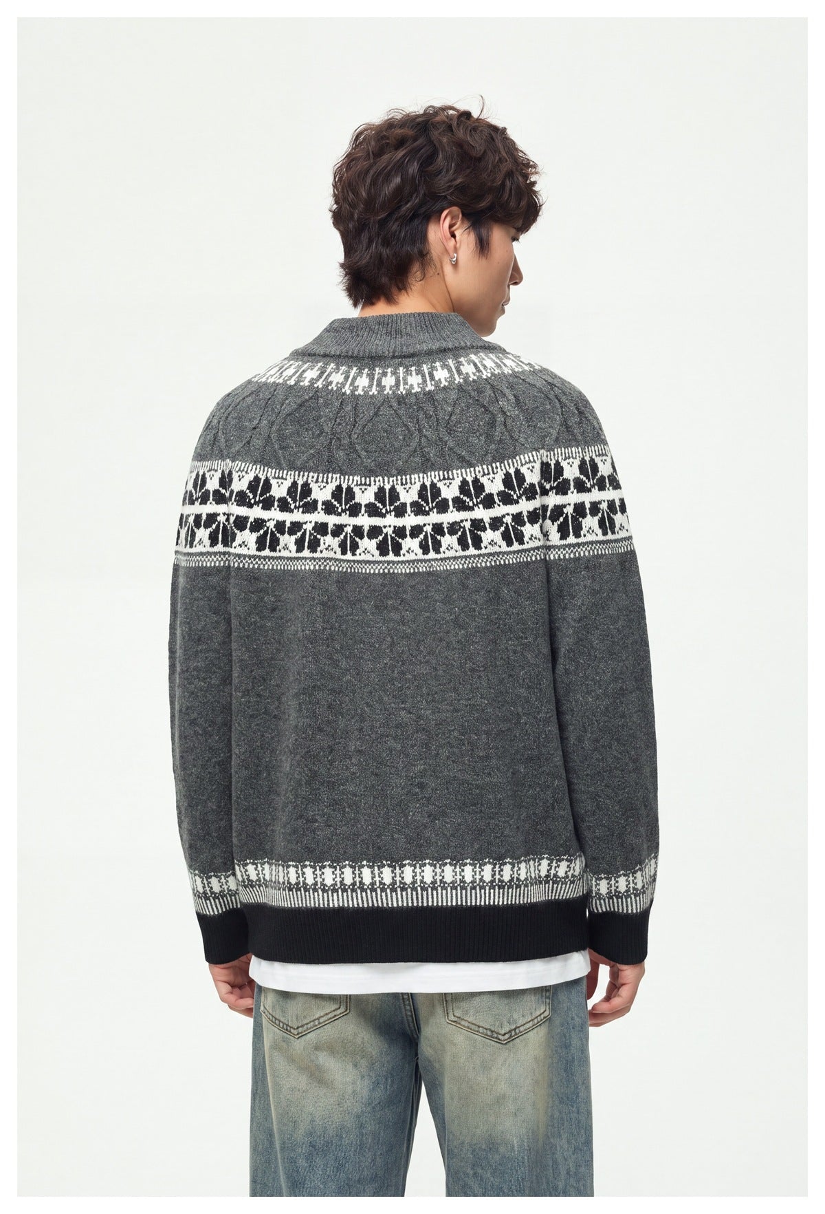Rear view of a model wearing a charcoal knit cardigan with white patterned bands across the shoulders and hem.