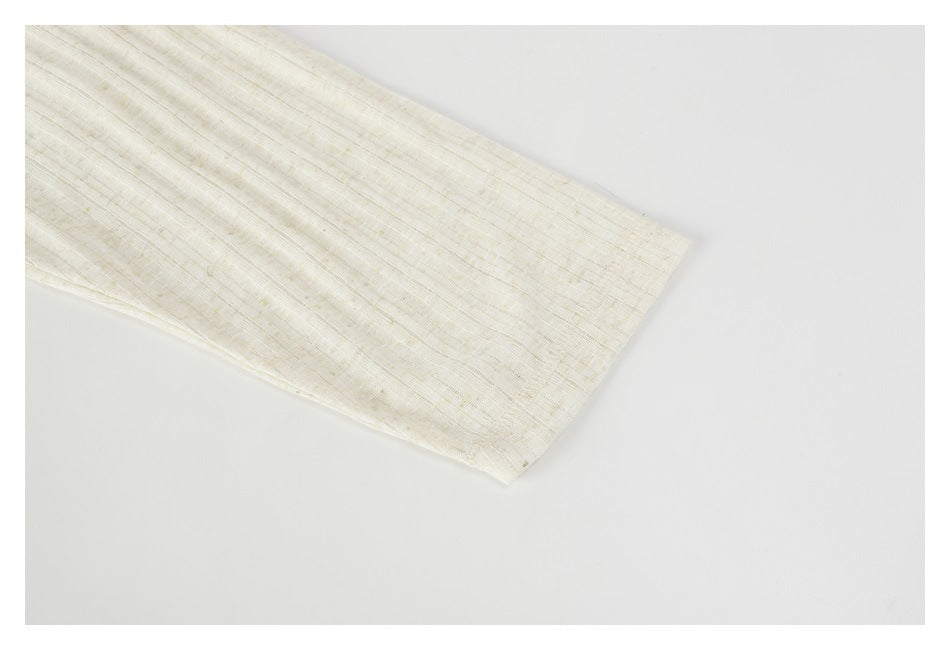 Close-up of a plain cream textured garment edge against a white background.