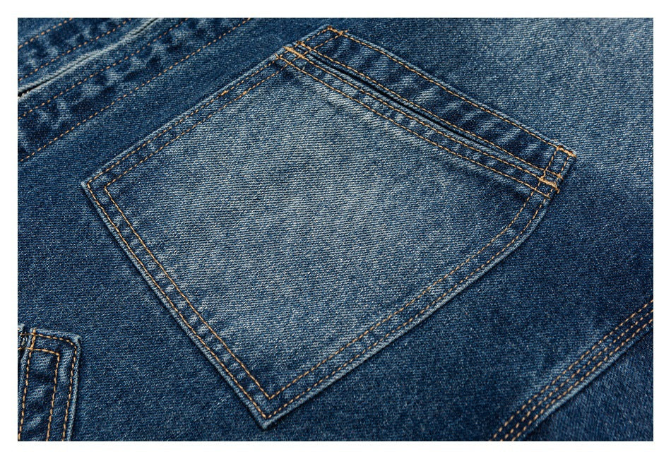 Close-up of a large patch pocket with contrasting tan stitching on blue denim.