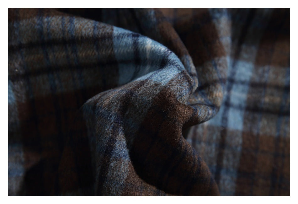 Close-up of dark brown and blue plaid fabric with a soft, brushed-looking surface.