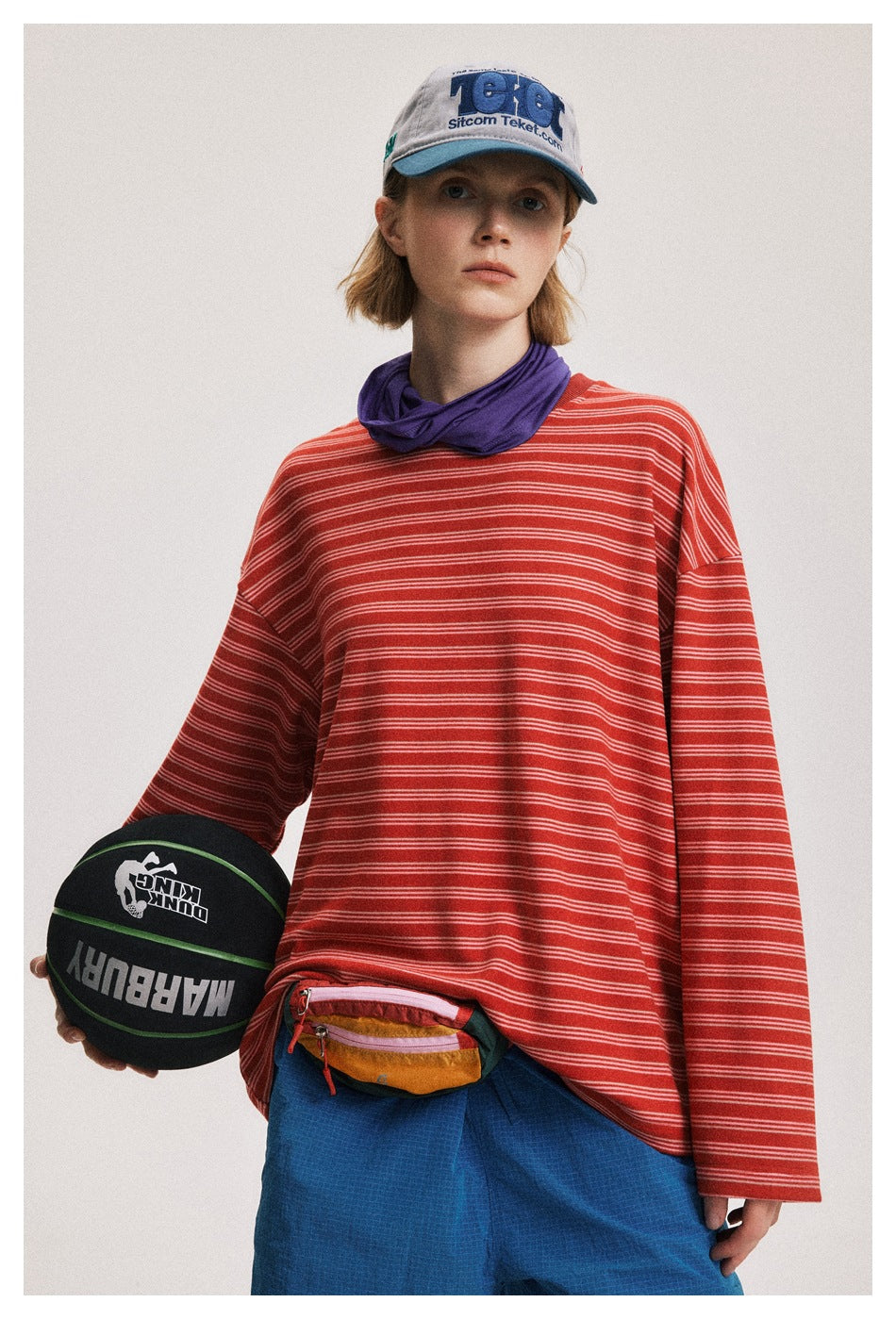 Model wearing an oversized red long-sleeve shirt with thin white stripes, shown from the front.