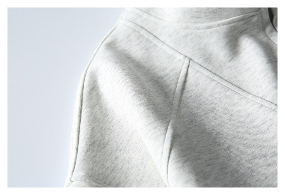 Close-up of the light gray heathered garment's shoulder seam and stitching.