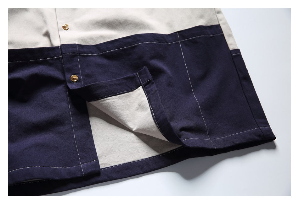 Close-up of the navy color-blocked shirt hem with a side slit showing the light beige underside.