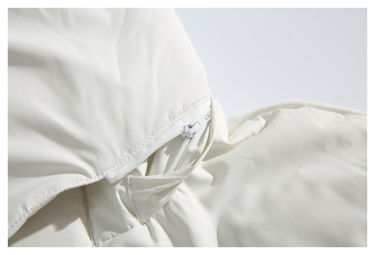 Close-up of a white zipper and drawcord detail on the ivory jacket.