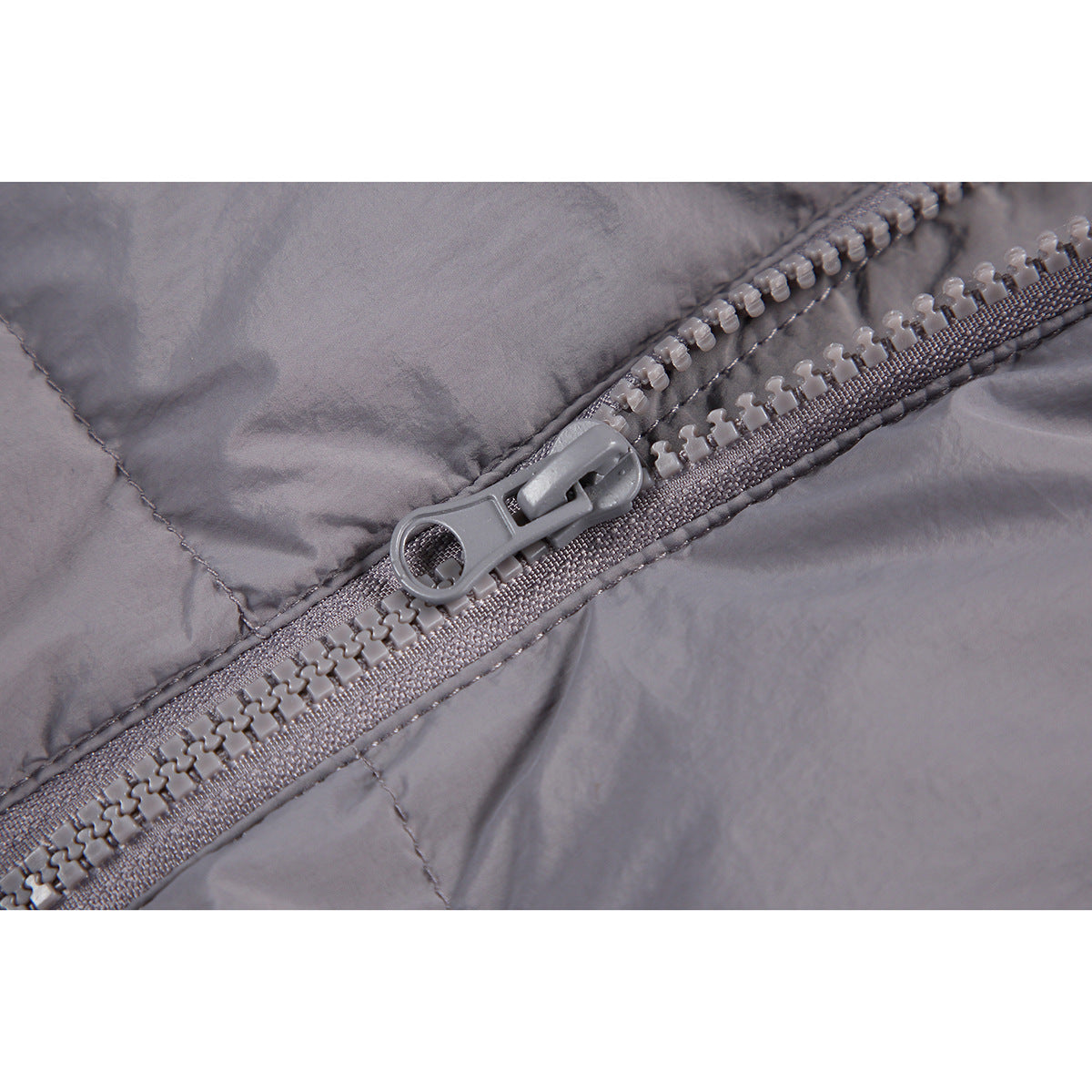 Close-up of the gray jacket's chunky front zipper and pull.