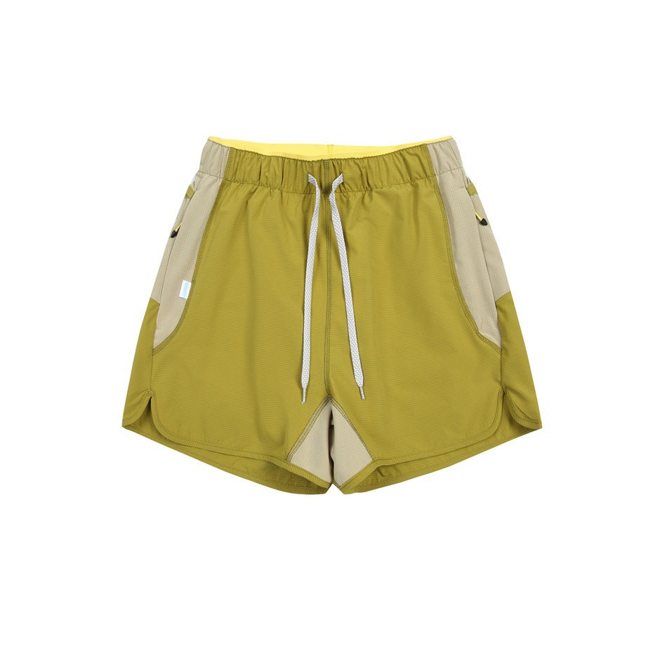 Olive green drawstring shorts with beige side panels and yellow waistband lining, flat lay front view