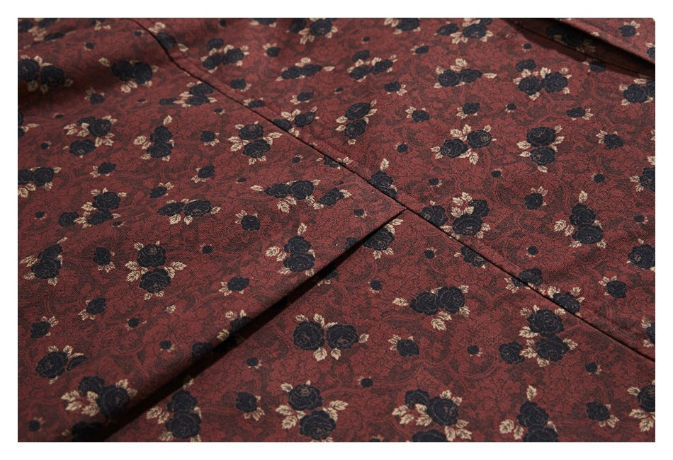 Close-up of intersecting seams on reddish-brown fabric with a black and cream floral pattern.