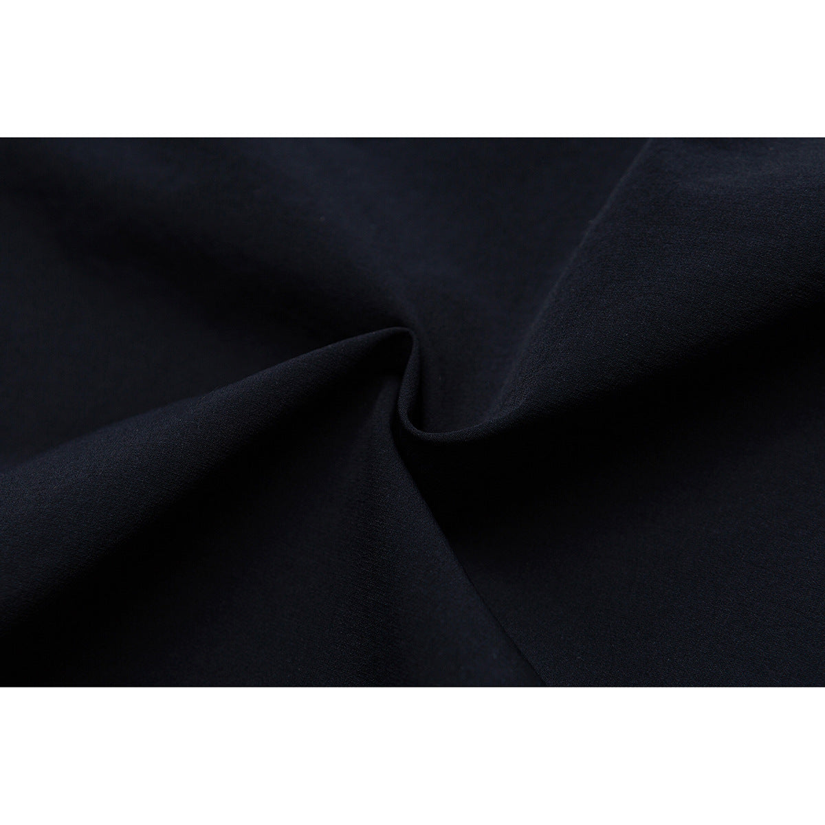 Macro view of dark navy fabric draped into soft folds.