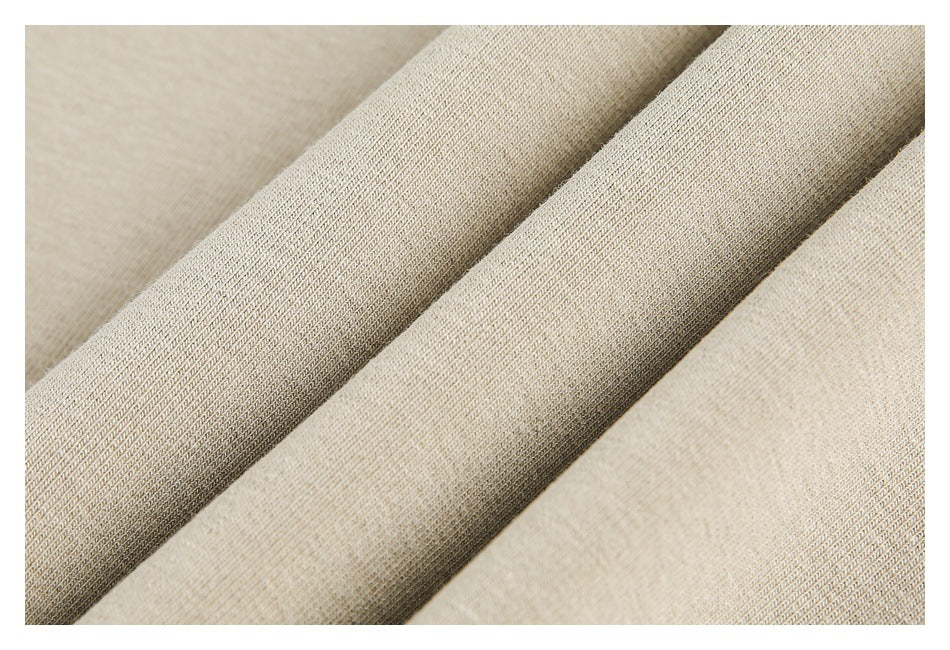 Extreme close-up of beige fabric folds showing its fine knit texture.