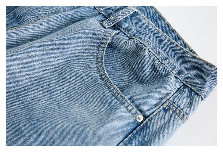 Close-up of a front pocket, belt loop, and faded light blue denim.