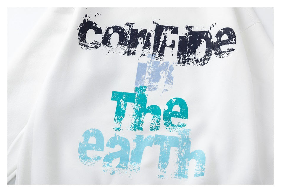Close-up of a white sweatshirt with distressed navy, pale blue and teal lettering reading “Confide … The earth.”