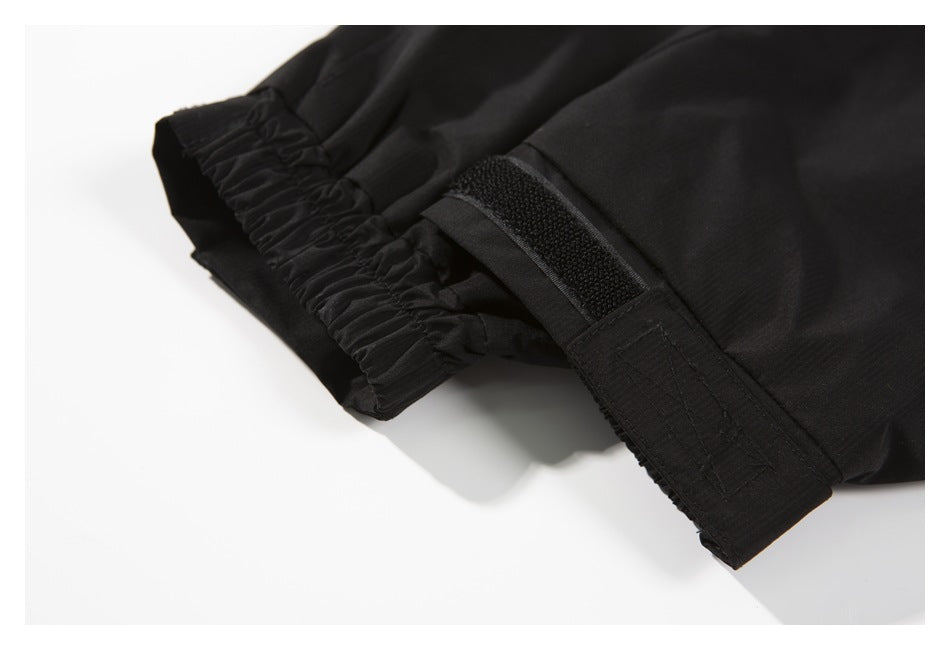 Close-up of a black garment cuff with gathered elastic and an adjustable hook-and-loop strap.