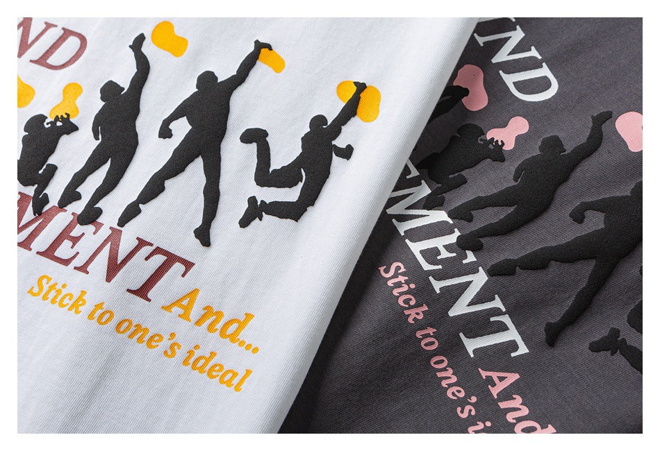 Close-up of white and charcoal T-shirts with black dancing silhouettes and English slogan prints in contrasting colors.