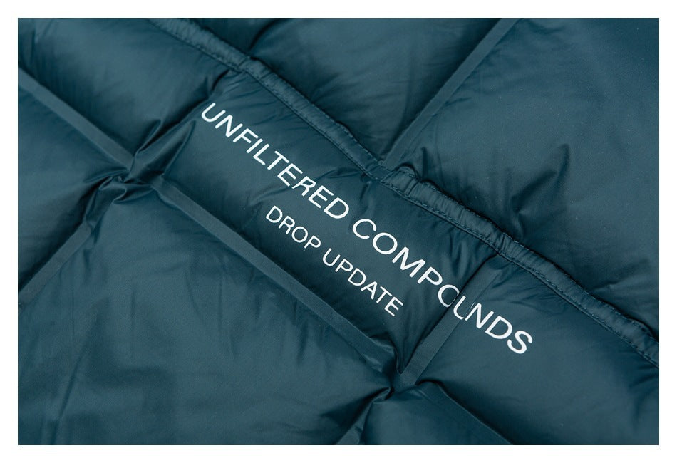 Close-up of teal padded fabric printed with the white words “UNFILTERED COMPOUNDS” and “DROP UPDATE.”