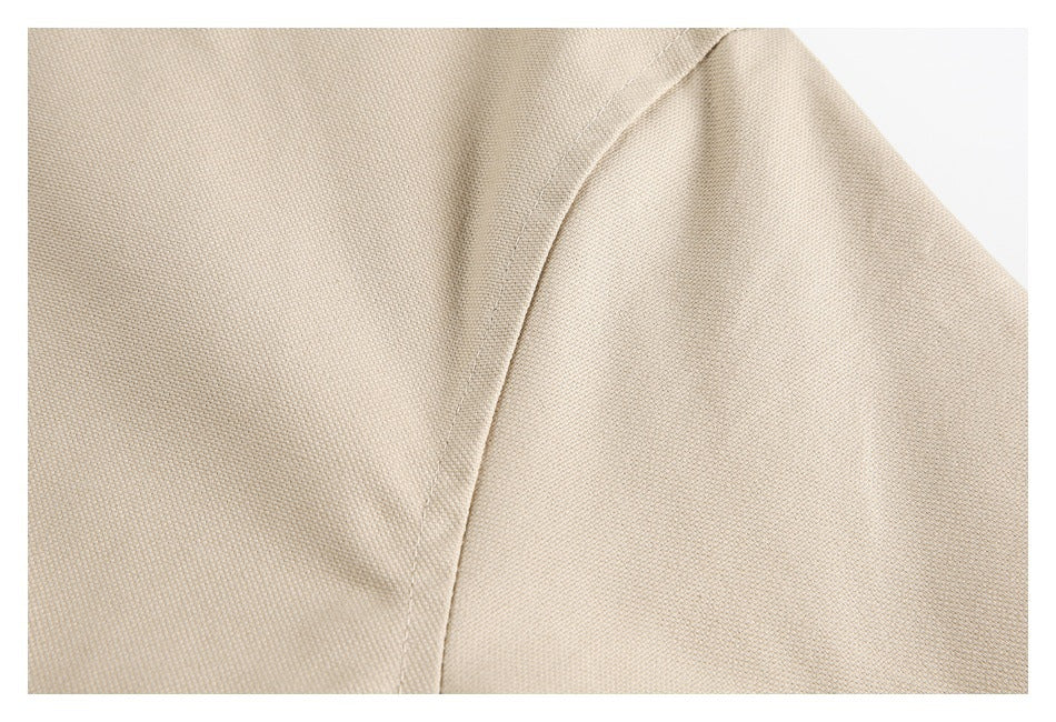 Close-up of beige garment fabric and curved stitched seam.