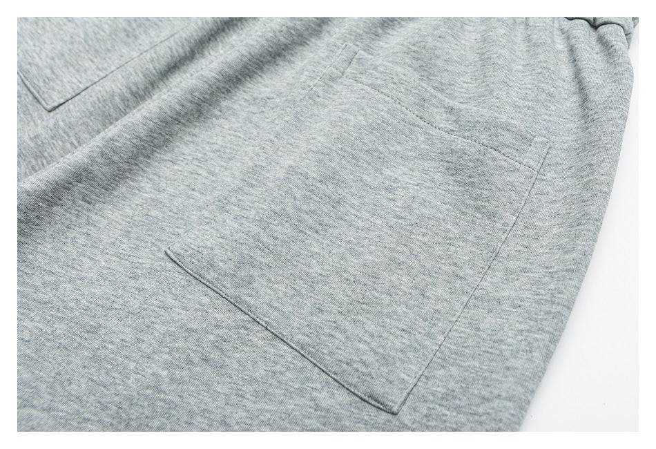 Close-up of a rectangular patch pocket on heather gray shorts.