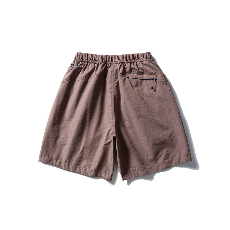 Back view of dusty mauve shorts with an elastic waistband and a zip pocket.