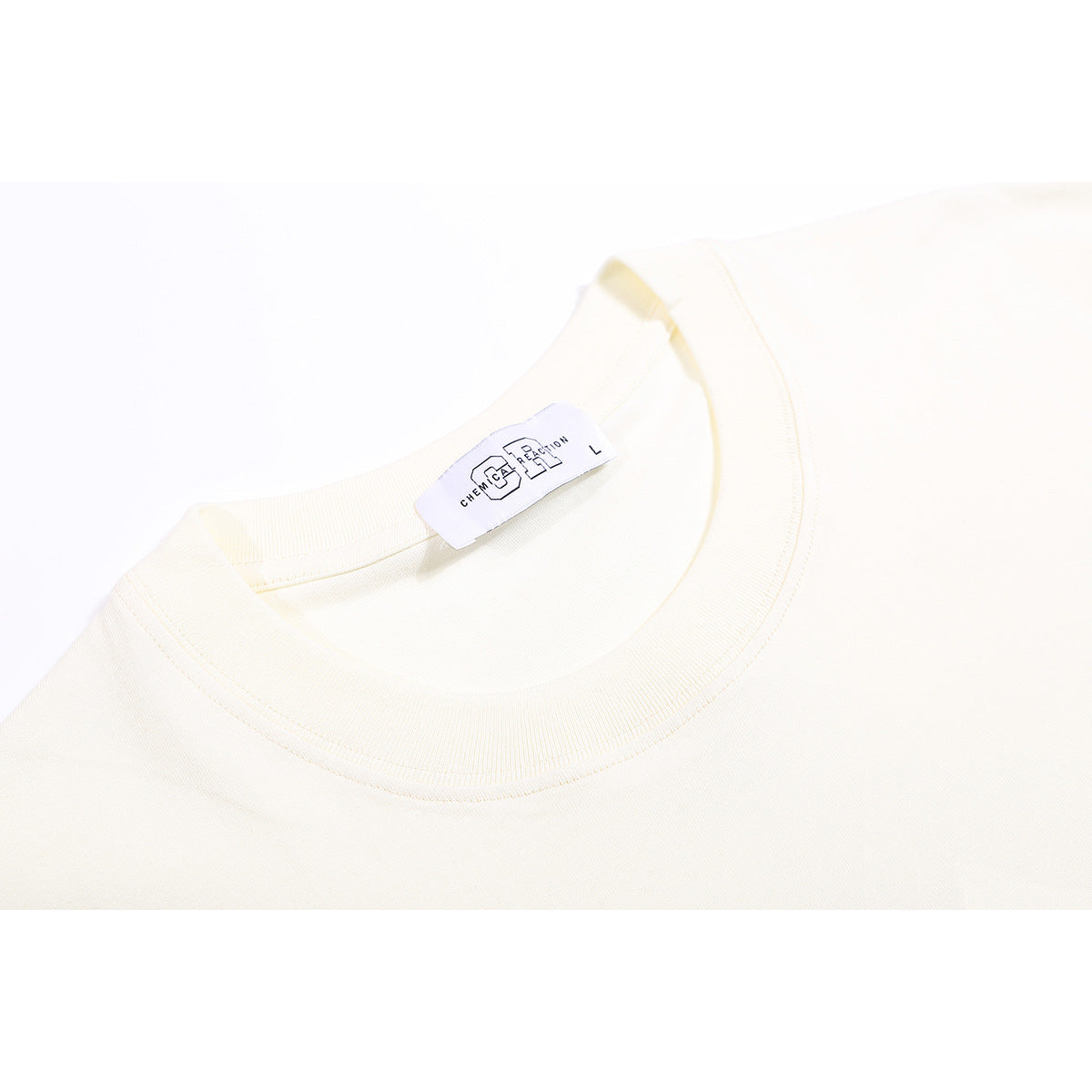 Close-up of an ivory T-shirt's ribbed crew neck and inner label.