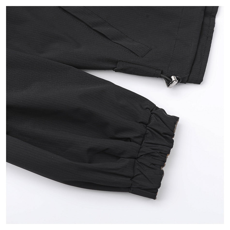 Close-up of black garment hems, showing a gathered cuff and an adjustable toggle at the edge.