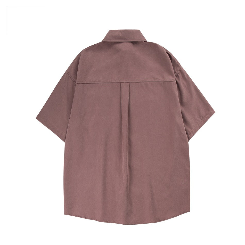 Back view of a dusty rose oversized short-sleeve collared shirt with a center pleat.