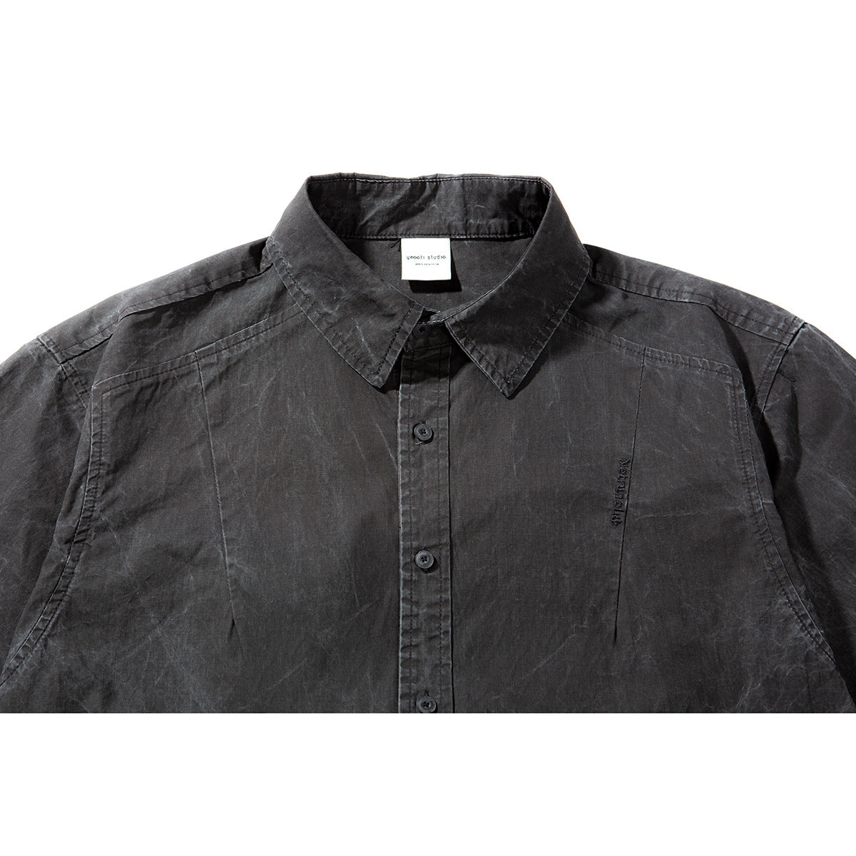 Close-up of a charcoal short-sleeve button-up shirt showing its pointed collar, placket and subtle chest embroidery.