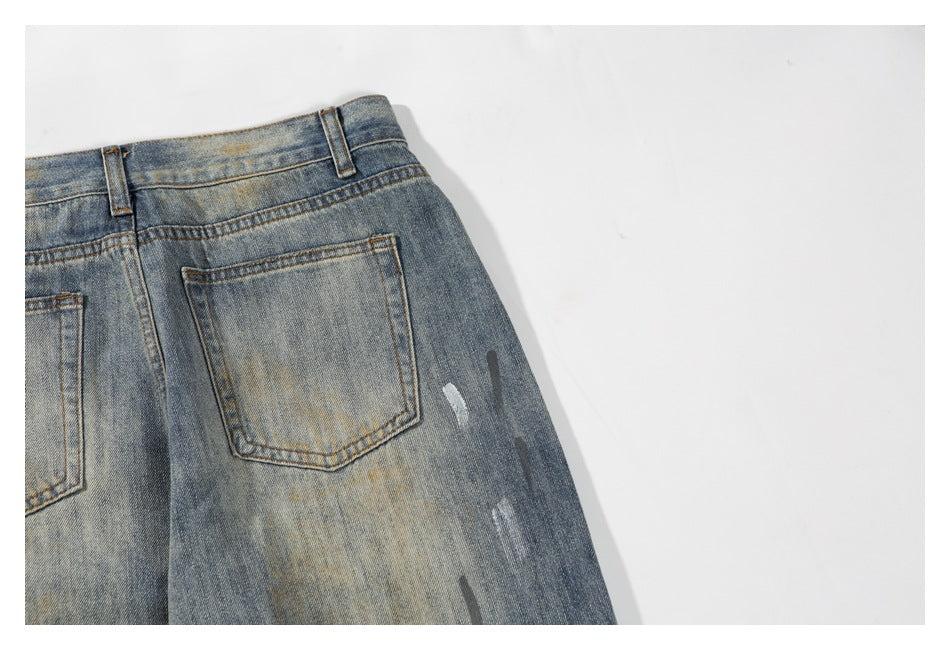 Partial rear view of faded blue jeans showing a patch pocket, waistband, and distressed marks.