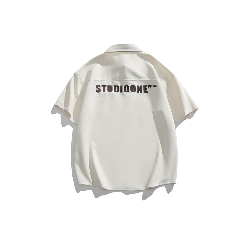 Back view of an apricot short-sleeve shirt with a large dark brown block-letter print across the upper back