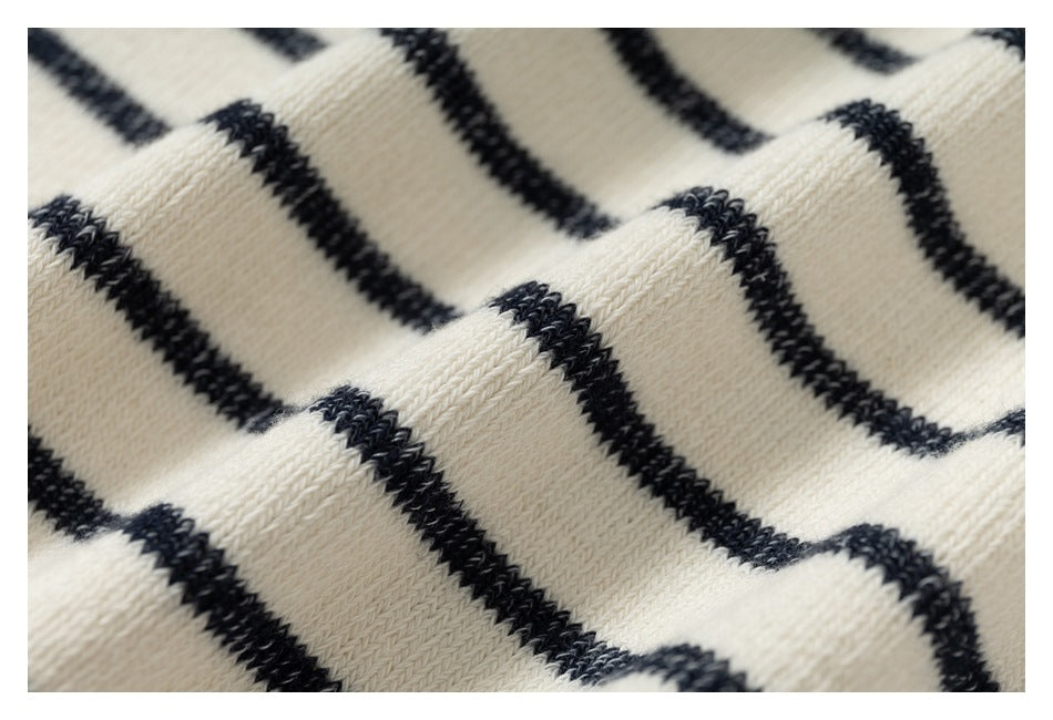 Close-up showing the textured knit and black stripes on cream fabric.