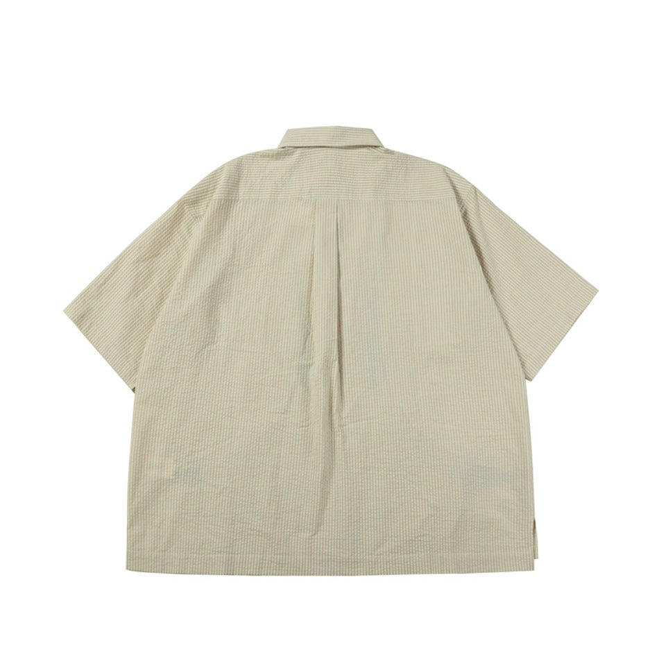 Back view of a beige short-sleeve button-up shirt with fine stripes and a center pleat.