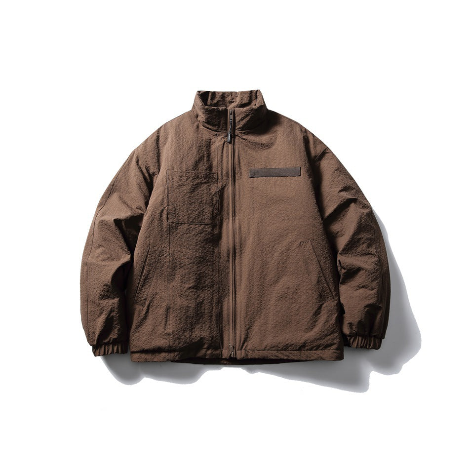Brown stand-collar zip jacket with textured surface, chest patch and pocket, flat front view