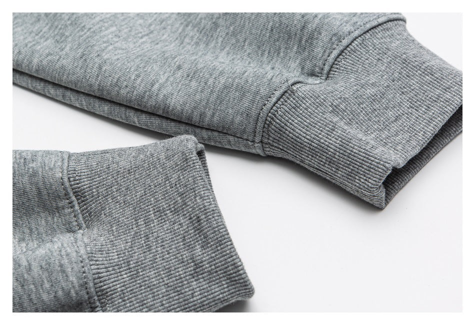 Close-up of the ribbed cuffs and sleeve seams on a heather gray sweatshirt.
