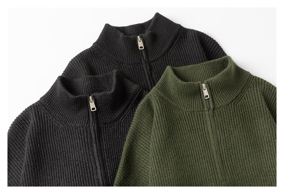 Close-up of black and olive rib-knit sweaters with stand collars and short front zippers.