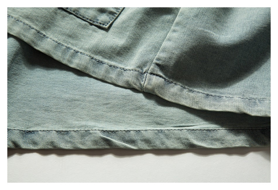 Close-up of light blue denim showing a curved stitched seam and lower hem.