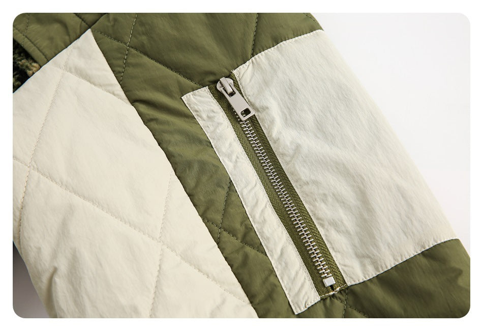 Close-up of a silver zipper on the olive and cream quilted jacket.